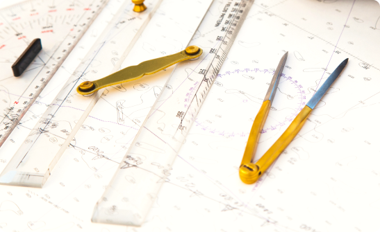 a table on which lie a compass and a ruler with a map